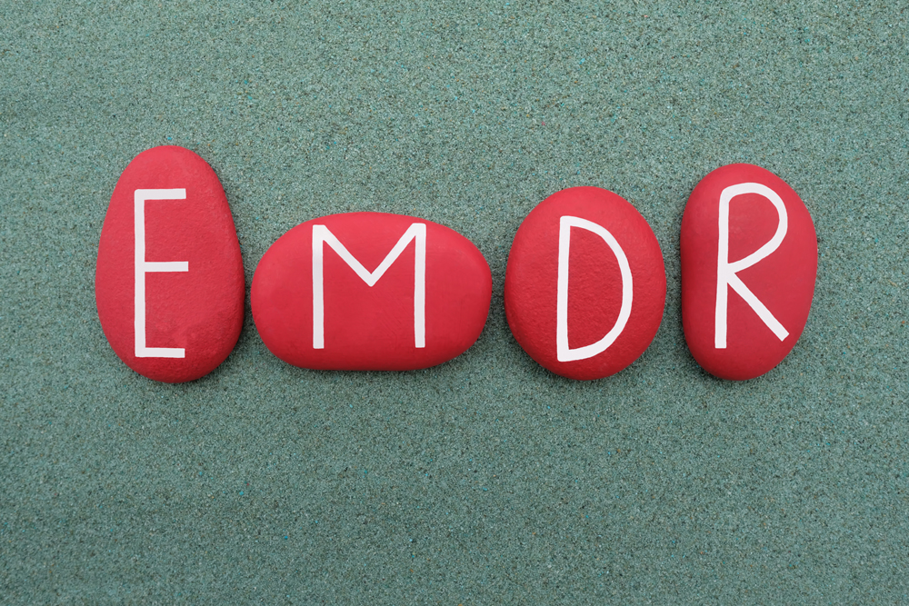 Red rocks lay on the ground, with painted letters on each spelling out "EMDR"